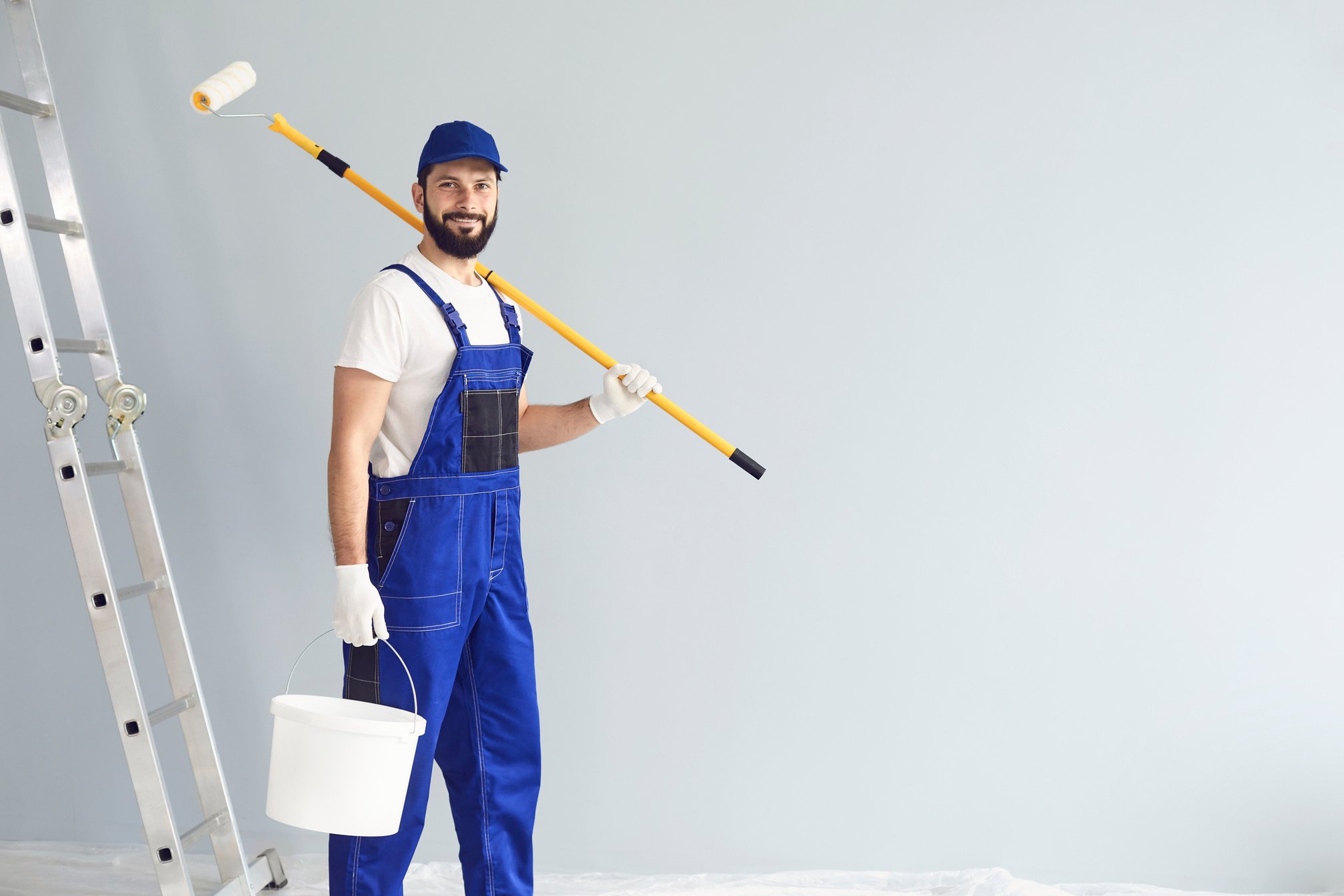 Positive Painter with Roller and Bucket on Gray Background